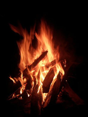 Warm flickering fire casting shadows on textured wooden table