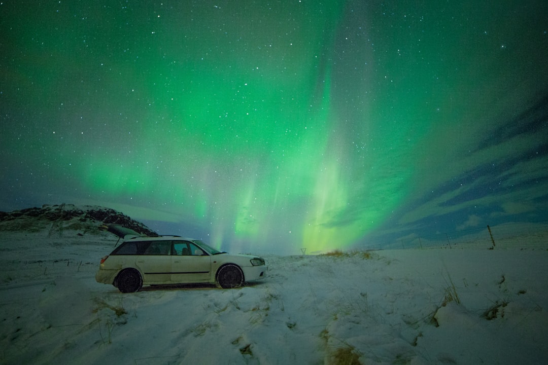 white station wagon under aurora borealis