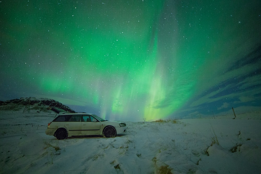 white station wagon under aurora borealis