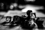 A collection of polyhedral dice scattered across a table with a blurred background, capturing a sense of mystery and focus on tabletop gaming.