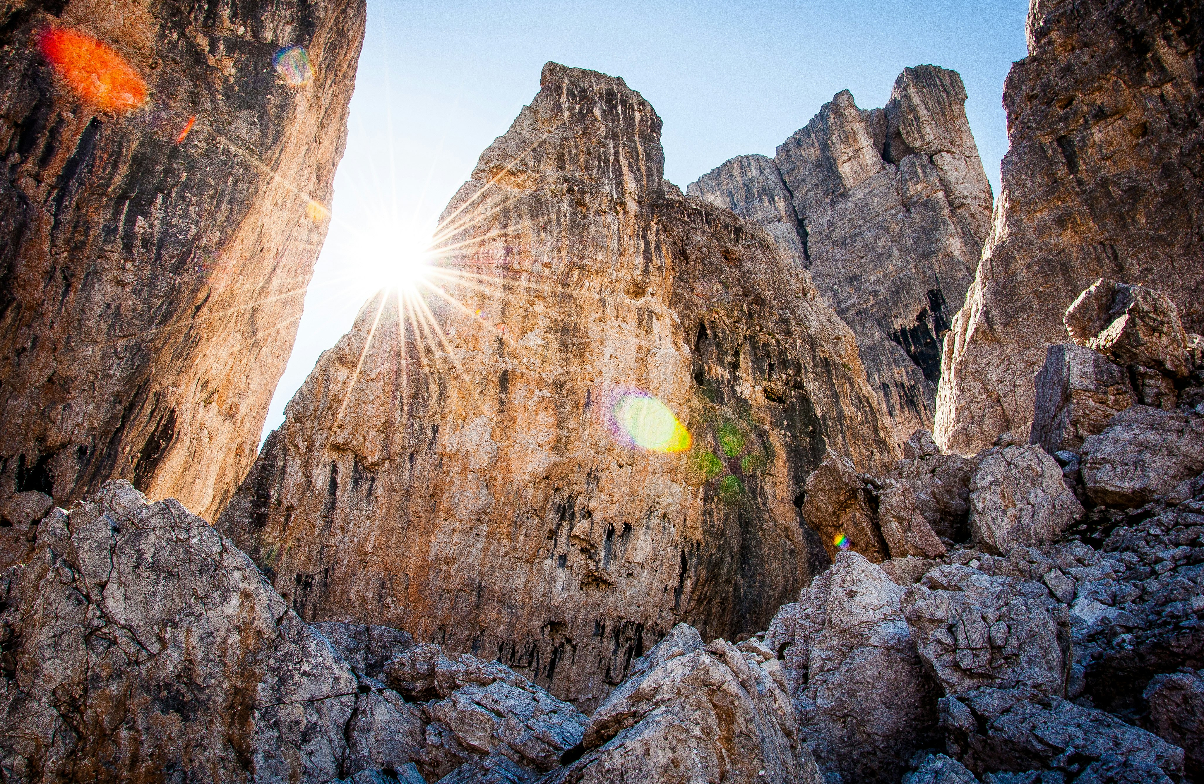 low-angle photography of brown rocky mountain under blue sky at daytime