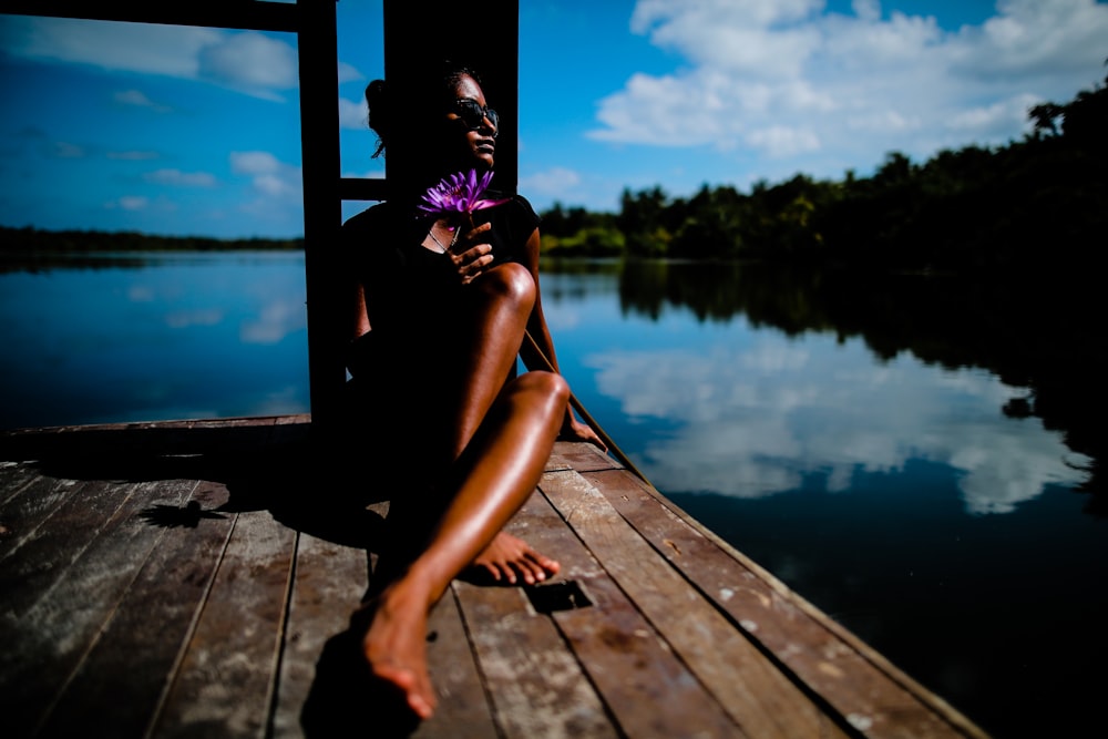 woman sitting near body of water