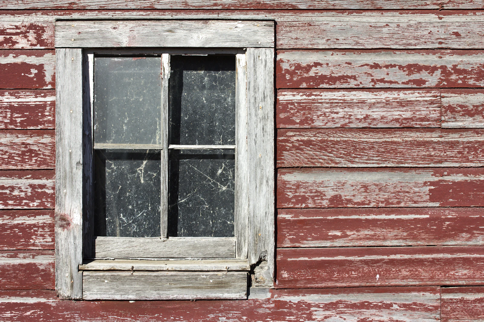 Old four-panel window with a weathered grey wooden frame