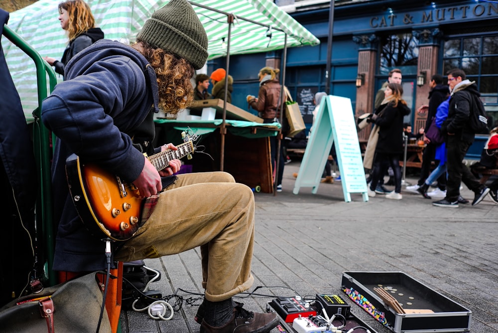 man playing electric guitar near on people