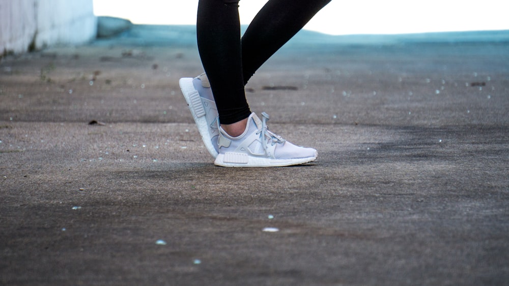 Foto mit flachem Fokus einer Person mit grauen Laufschuhen