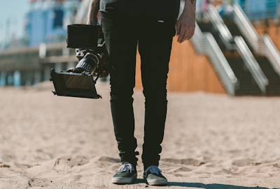 Vue partielle d'un cadreur en pleine action, avec uniquement ses mains et ses jambes visibles. 