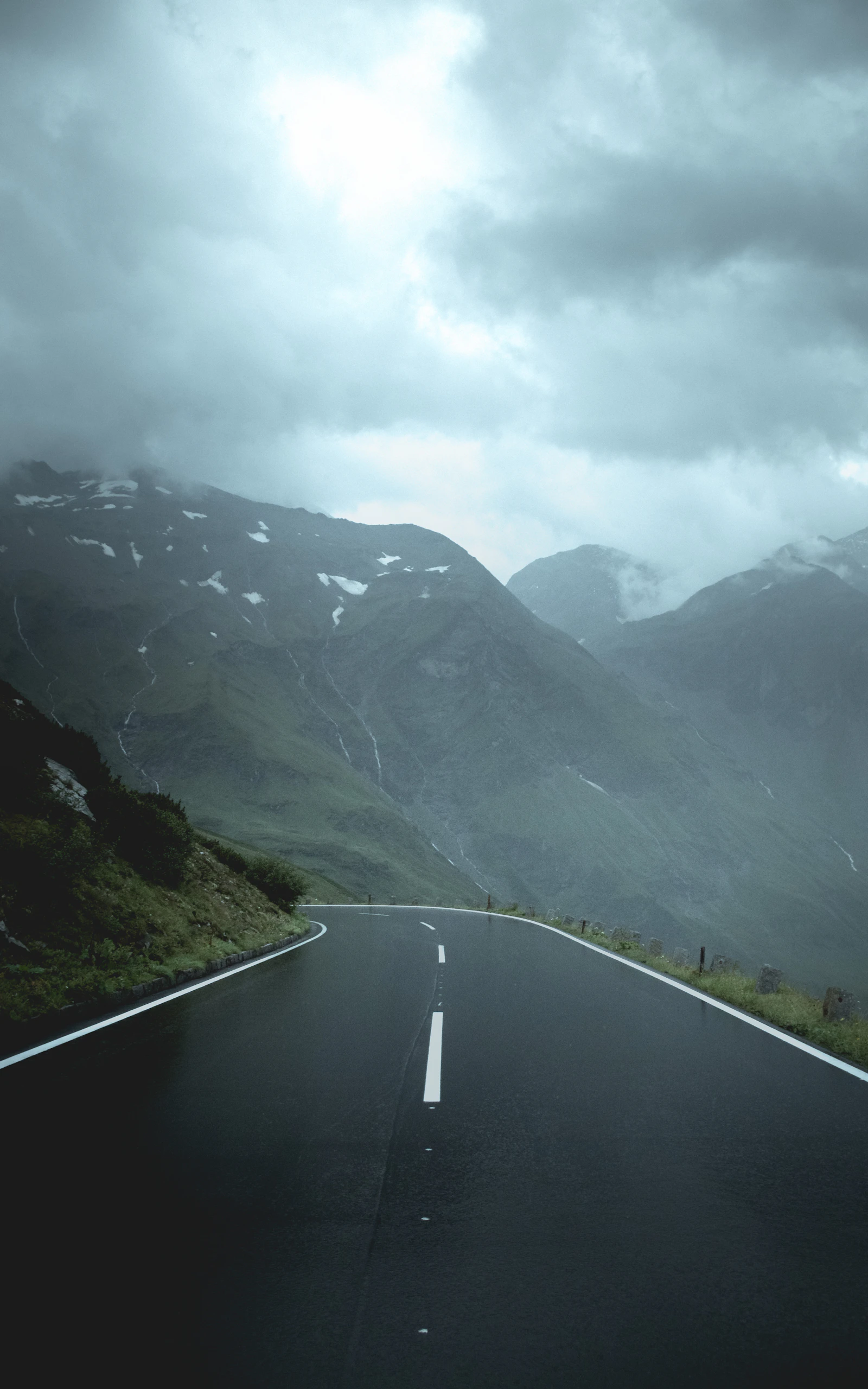 Road entering a steep Austrian valley beneath low cloud