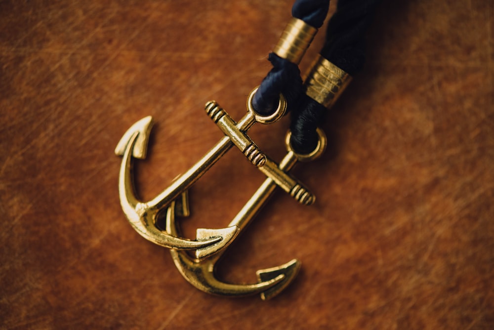 two gold-colored anchor pendants