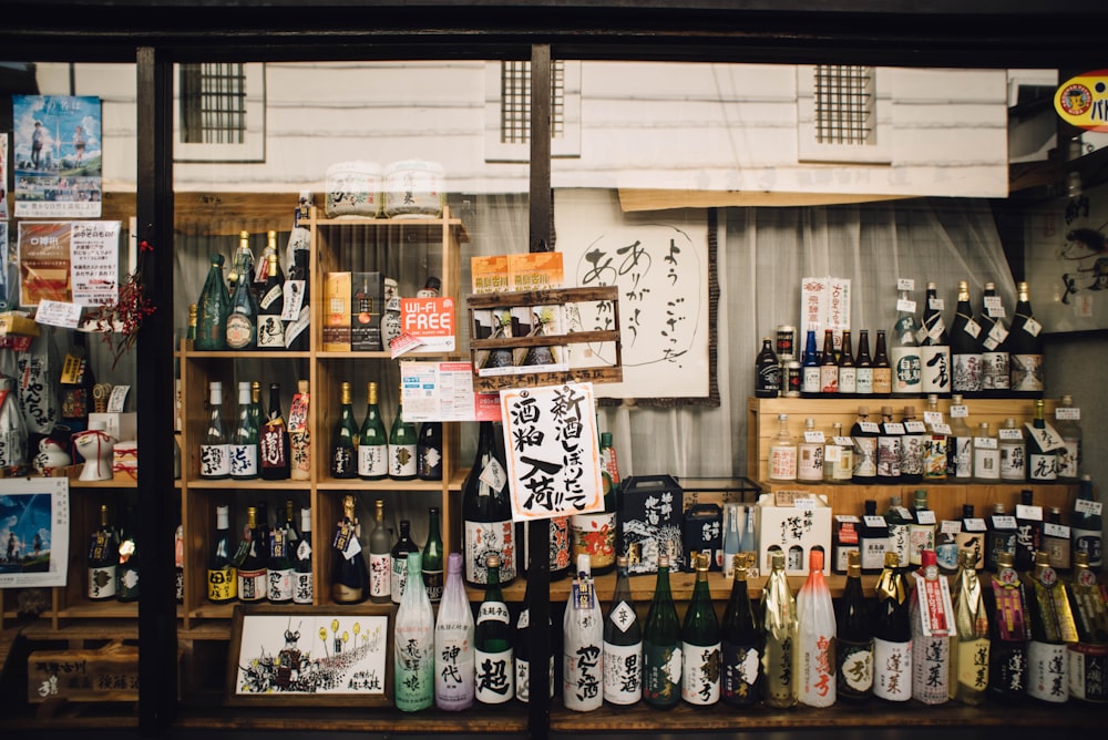 assorted glass bottles on wooden shelf