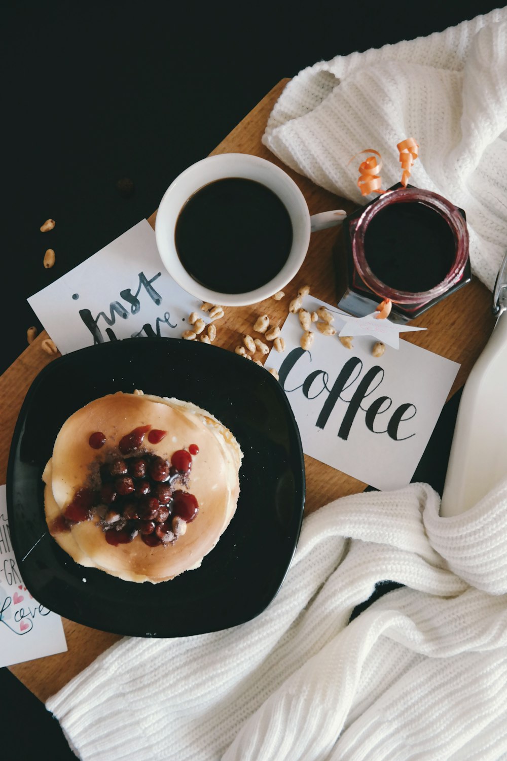 Fruit covered pancakes with coffee.