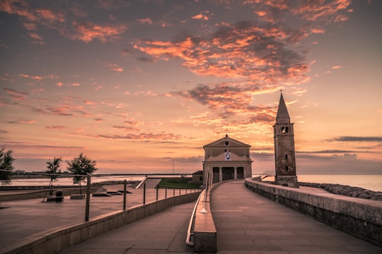 brown wooden dock near brown concrete building during sunset in Madonna dell'Angelo Italy