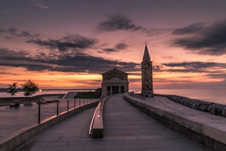 brown wooden dock near brown concrete building during sunset