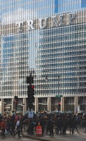 people walking on road beside Trump building