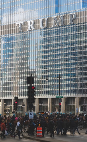 people walking on road beside Trump building
