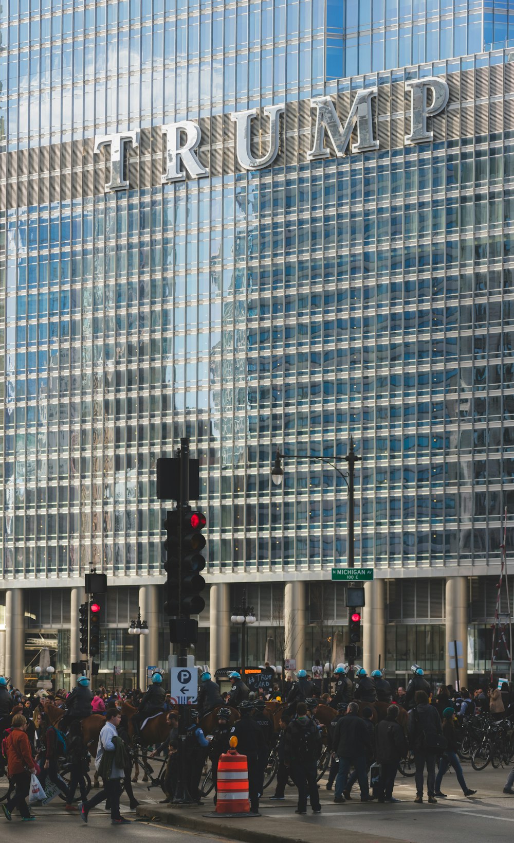 gente caminando por la carretera al lado del edificio Trump