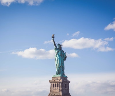 Statue of Liberty, New York under white and blue cloudy skies