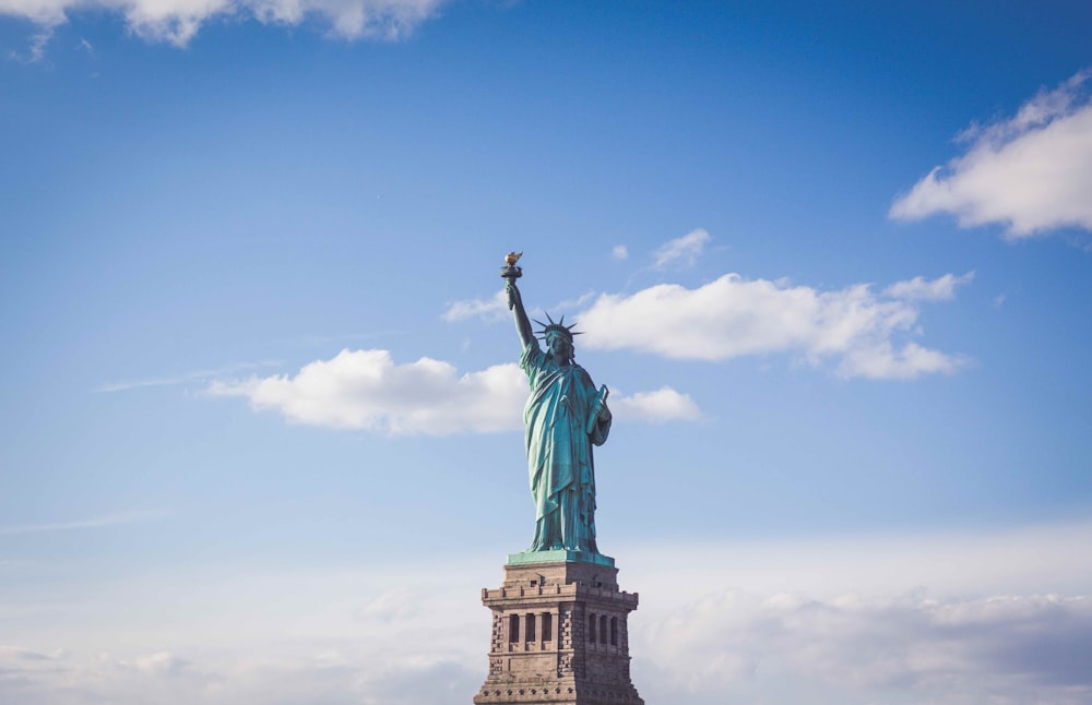 Estatua de la Libertad, Nueva York bajo cielos nublados blancos y azules