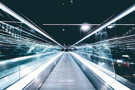 gray conveyor between glass frames at nighttime