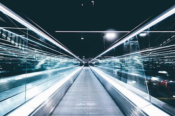 gray conveyor between glass frames at nighttime