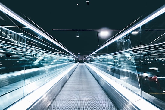 gray conveyor between glass frames at nighttime