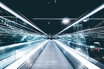 gray conveyor between glass frames at nighttime new world zoom background