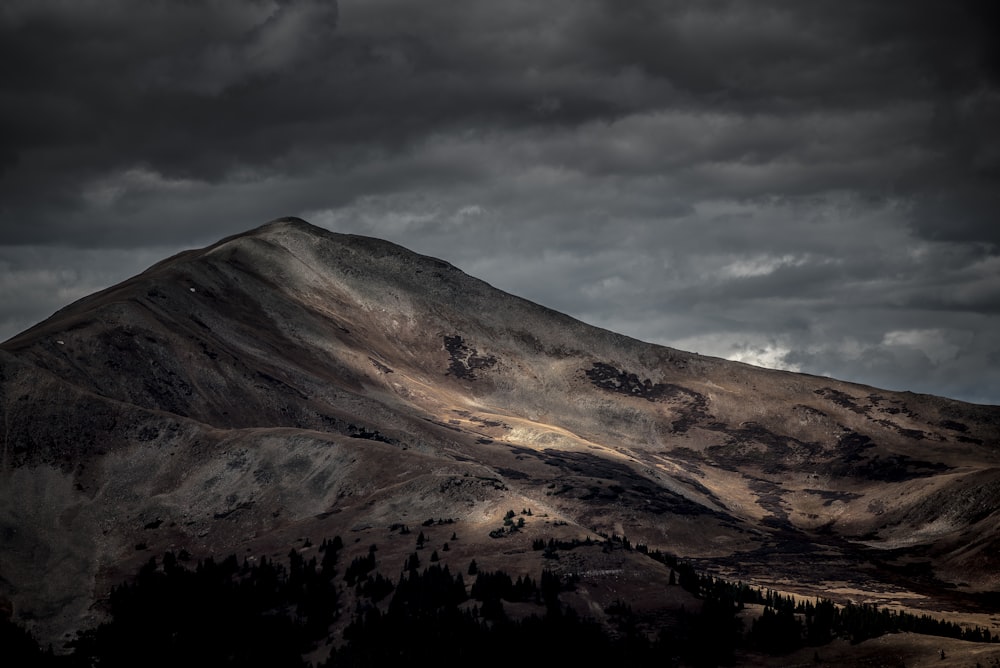 brown mountain under gray sky