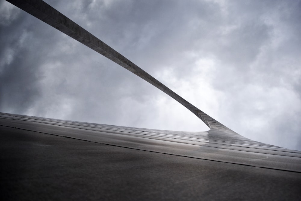 Graustufen-Flachwinkelfotografie von Arc Gate unter bewölktem Himmel