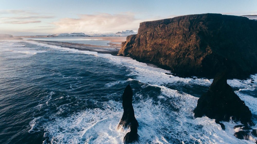 photo of rock formations on body of water