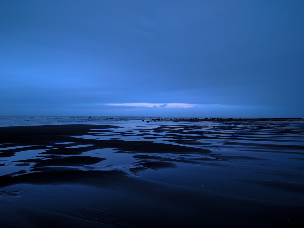 un ciel bleu foncé au-dessus de l’océan la nuit