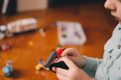 A cute cartoon baby boy playing with building blocks shaped like blueprints.