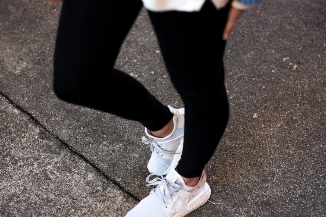person wearing white Adidas NMD sneakers