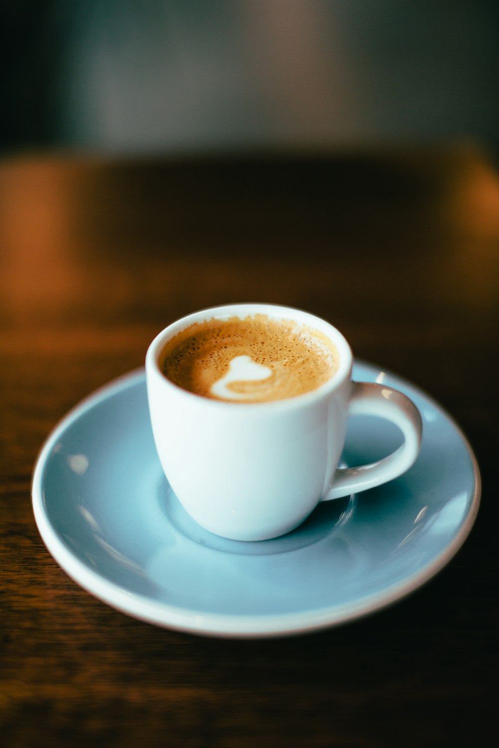 Fotografia com foco seletivo de café com leite em xícara de chá