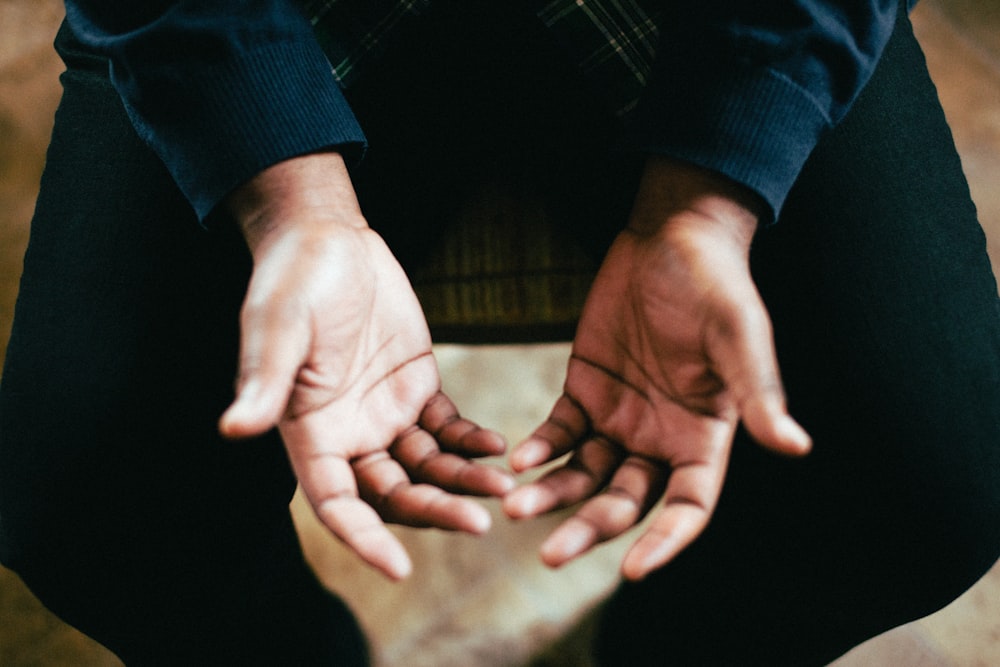 person showing both palms while sitting on chair