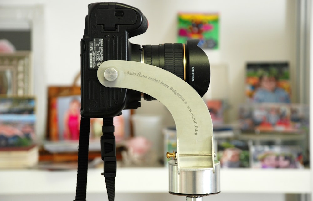 グレーの金属製カメラホルダーに黒いデジタル一眼レフカメラ