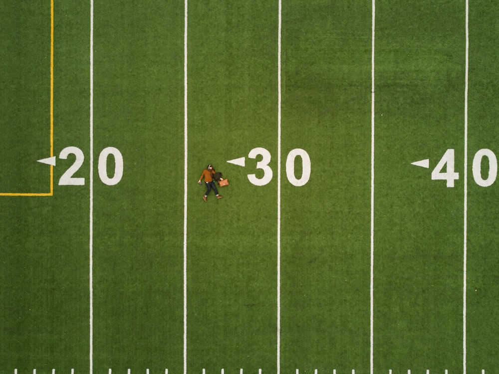 man lying on 30 yards on football field