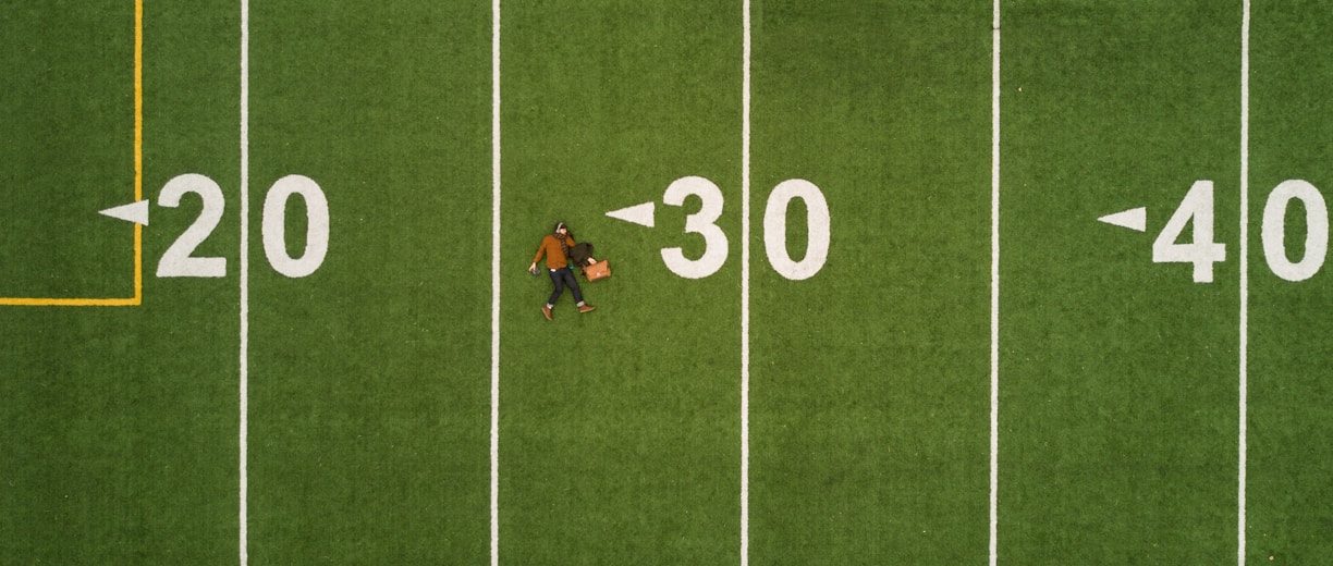 man lying on 30 yards on football field