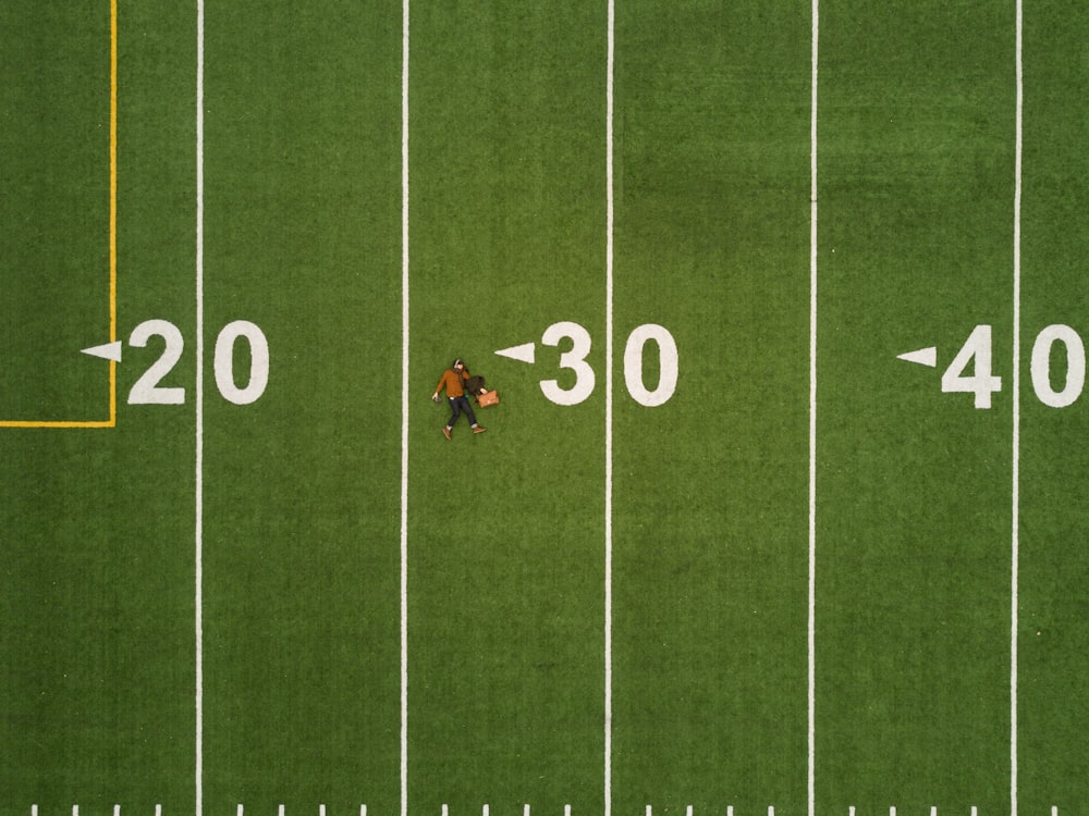 Drone aerial view of a person lying on the back on a football pitch in Montreal