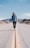 man walking in the middle on road at daylight