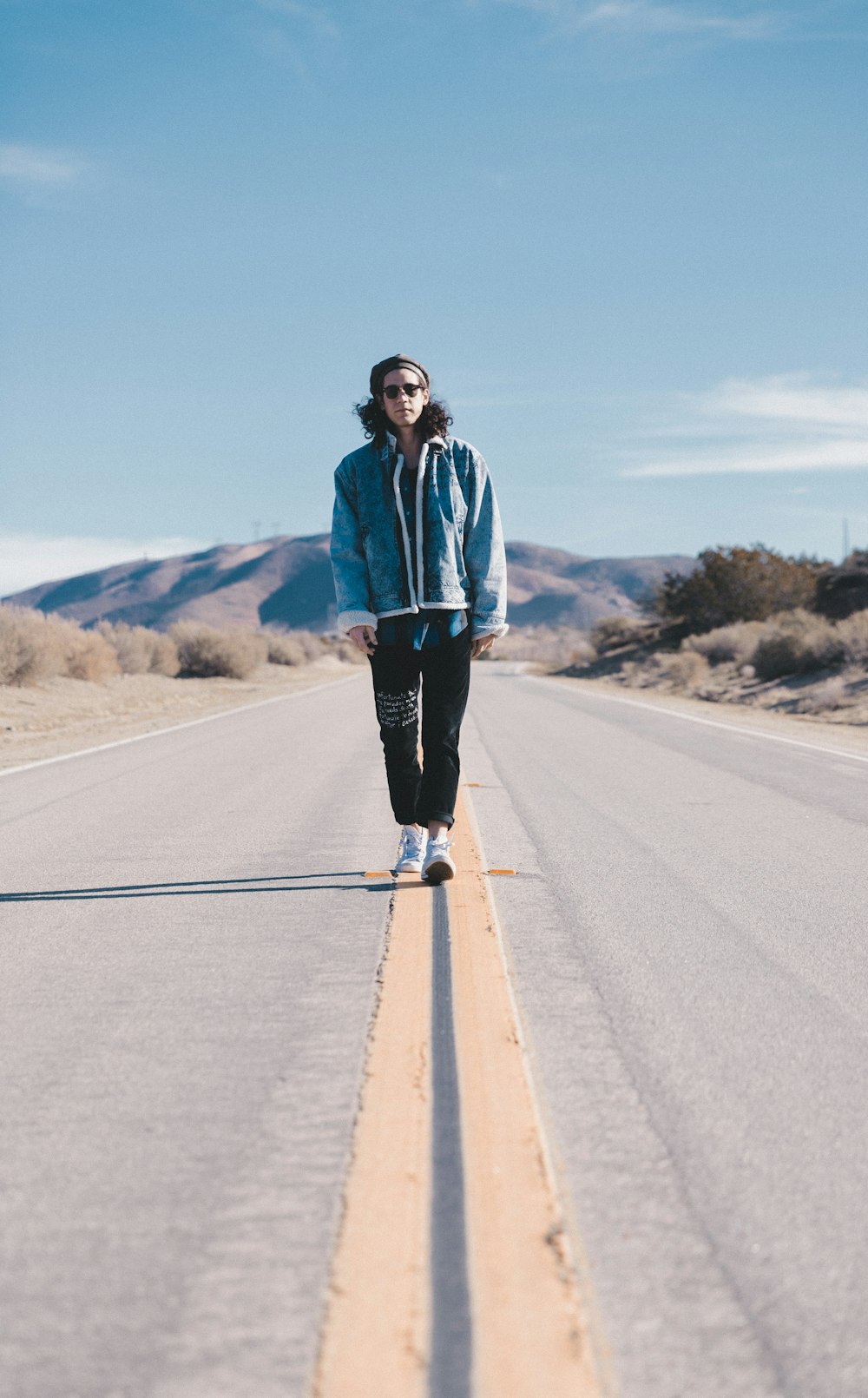 man walking in the middle on road at daylight