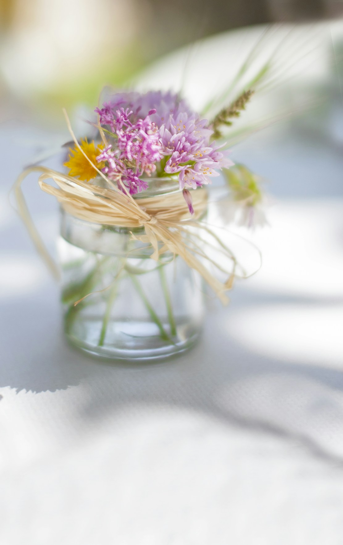 A close-up of freshly picked wildflowers from Tabby Meadows arranged in a rustic mason jar.