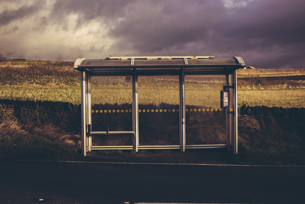 gray and black waiting shed under cloudy sky