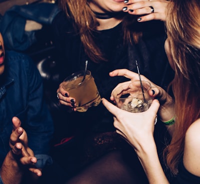 two women talking while holding drinking glasses