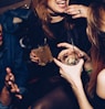two women talking while holding drinking glasses