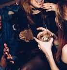 two women talking while holding drinking glasses