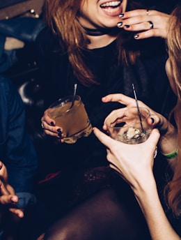 two women talking while holding drinking glasses