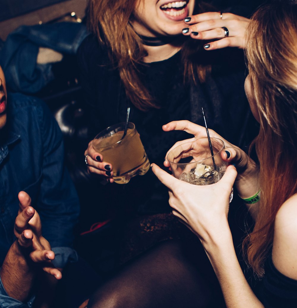 two women talking while holding drinking glasses