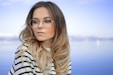 woman wearing black and white striped top and round eyeglasses