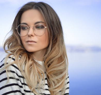 woman wearing black and white striped top and round eyeglasses