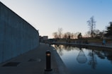 Elegant twilight view of a sleek water garden with soft lighting casting shadows on polished stone.