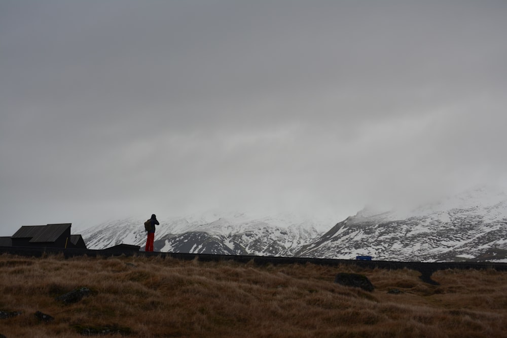 pessoa em pé na frente da montanha